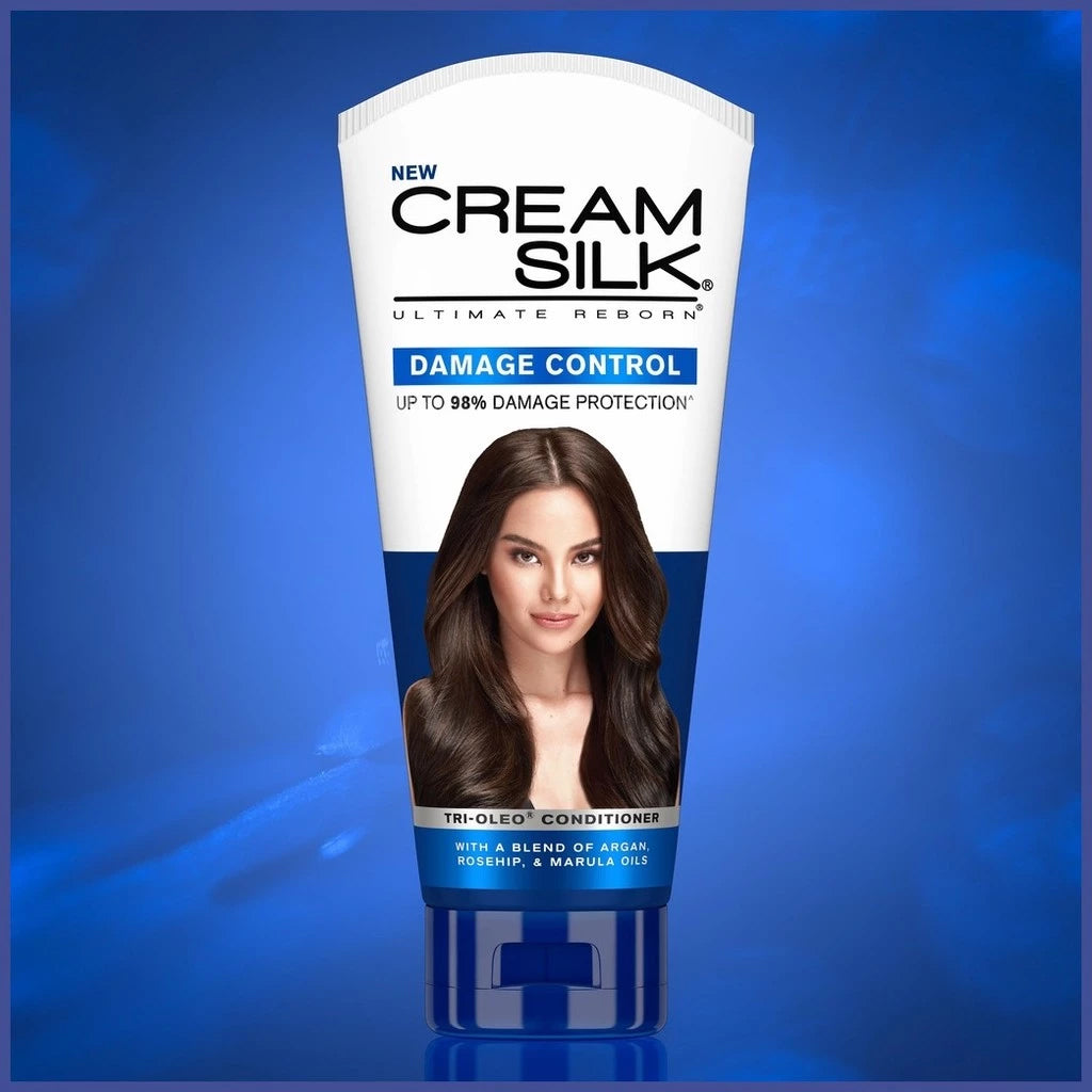 Cream Silk Damage Control conditioner tube on a blue background