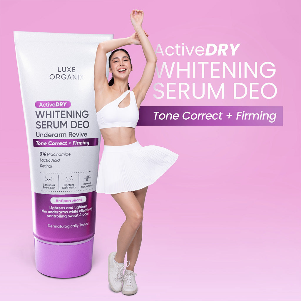 Woman in white outfit standing next to a Luxe Organics ActiveDry Whitening Serum Deo tube on a pink background